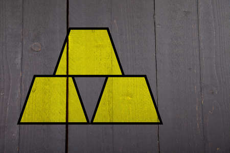 Three yellow gold bars on black wooden backgroundの写真素材