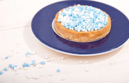 Traditional Dutch birth celebration biscuit with blue muisjes on wooden backgroundの写真素材