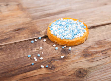 Traditional Dutch birth celebration biscuit with blue muisjes on wooden backgroundの写真素材
