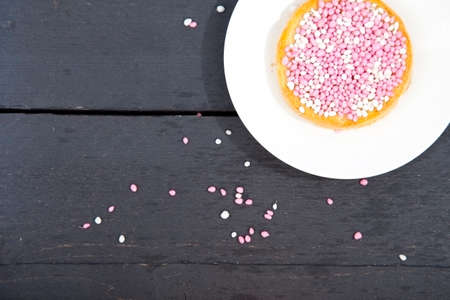 Traditional Dutch birth celebration biscuit with pink muisjes on wooden backgroundの写真素材