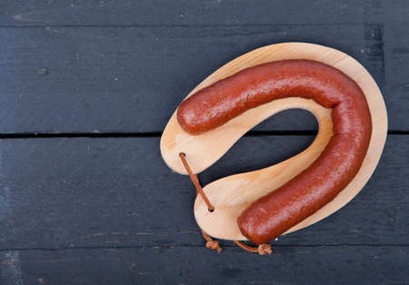 Traditional Dutch smoked sausage called Rookworst on wooden backgroundの写真素材