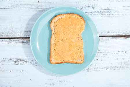 Bread with peanut butter on wooden backgroundの写真素材