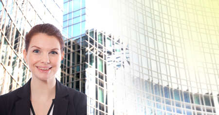 Young businesswoman in front of blurred office building backgroundの写真素材