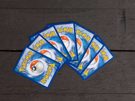 BEVERWIJK, THE NETHERLANDS - April 23, 2017: Several very popular Pokemon cards on dark wooden backgroundのeditorial素材
