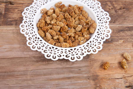 Dried mulberries on wooden backgroundの写真素材