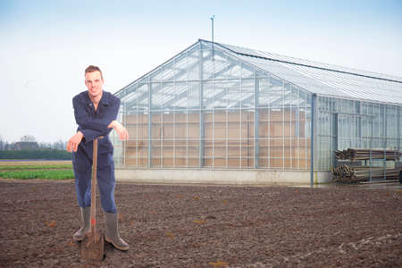 Young farmer outside a glass houseの写真素材