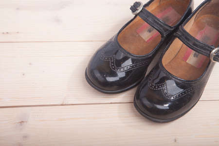 Little black shoes on wooden backgroundの写真素材
