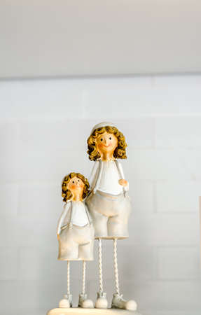 Two little ceramic dolls on the wooden shelfの写真素材