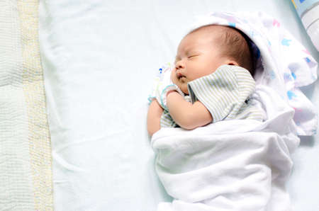 Peaceful baby lying on a bed while sleeping in a bed room