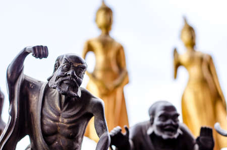 The black saint statue and the bured yellow buddha statueの写真素材