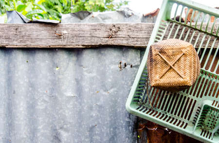 Thai bamboo sticky rice container on old wall background.の写真素材