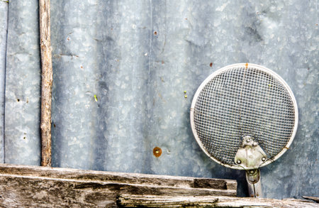 The old sieve keep on the old zinc wall in my homeの写真素材