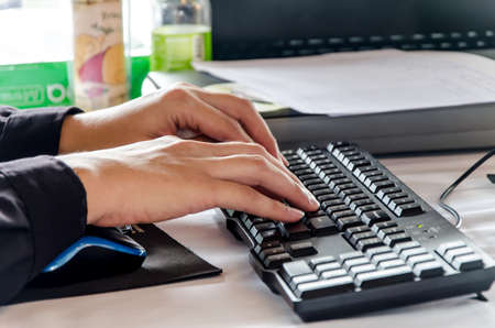 Hand typing on computer keyboard.