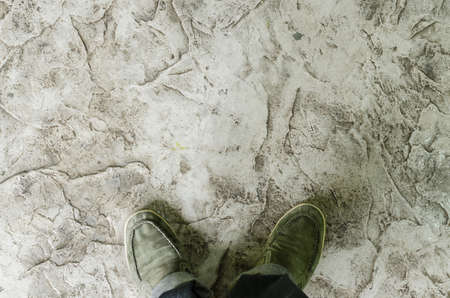 grungy gray background of natural cement and green shoes
