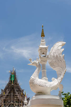 Thai white swan statue with on blue sky background at corner. White swan cement statue in Thai styleの写真素材