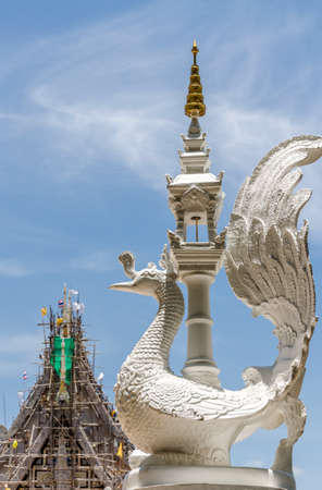 Thai white swan statue with on blue sky background at corner. White swan cement statue in Thai styleの写真素材