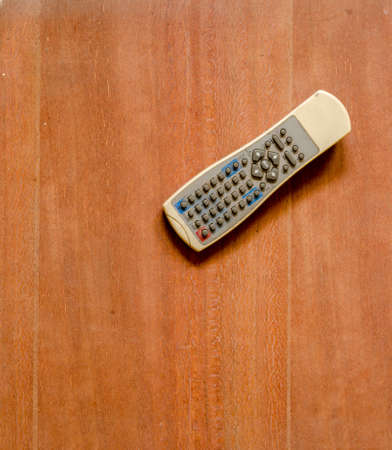 Old TV remote control on wood floorの写真素材