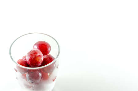 red grapes in glass on white backgroundの写真素材