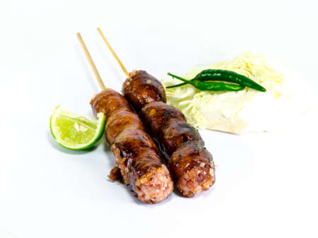 Thai Grilled Sausages on white background served with Cabbage and Chili Pepper. Thai Foodの写真素材