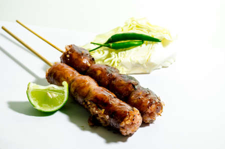 Thai Grilled Sausages on white background served with Cabbage and Chili Pepper. Thai Foodの写真素材
