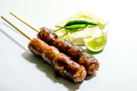 Thai Grilled Sausages on white background served with Cabbage and Chili Pepper. Thai Foodの写真素材