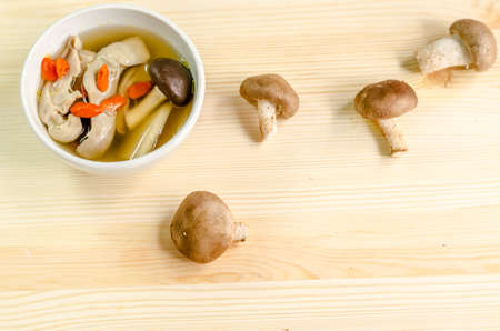 Traditional oriental pork broth with shiitake mushrooms on wooden tableの写真素材
