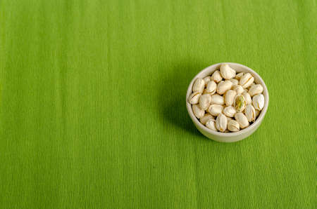 Pistachios Nuts on green Table cloth backgroundの写真素材