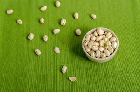 Pistachios Nuts on green Table cloth backgroundの写真素材