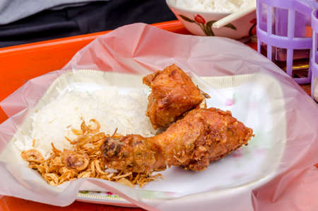 Fried chicken with sticky rice on red tableの写真素材
