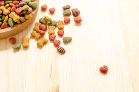 Dry dog food in wooden dish and wooden backgroundの写真素材