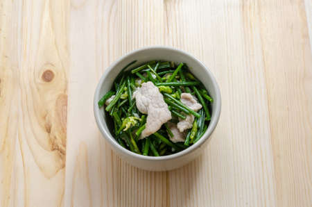 Stir Fried Pork with Chinese Chives Flower and Garlic on wooden backgroundの写真素材
