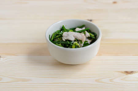 Stir Fried Pork with Chinese Chives Flower and Garlic on wooden backgroundの写真素材