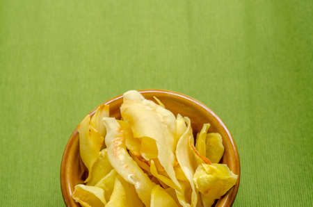 Durian chips fried snack fruit in brown blow on green backgroundの写真素材