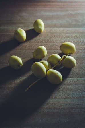 Group of fresh date palm fruits  on wooden backgroundの写真素材