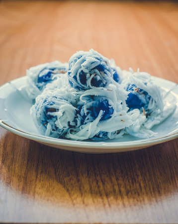 Thai dessert Coconut munchkins in white dish on wooden background: Vintage toneの写真素材