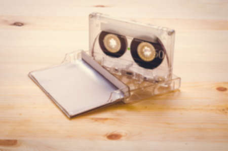 Burred cassette tape over wooden background. retro filterの写真素材