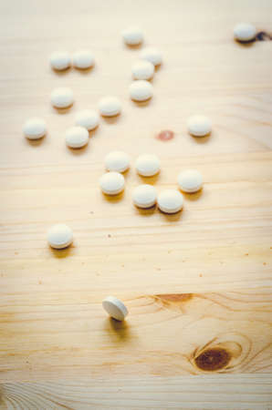 medicine tablets on wood backgroundの写真素材