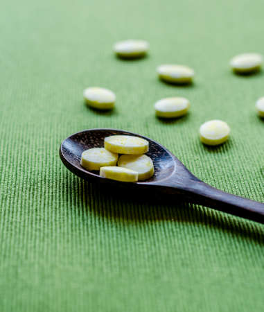 medicine tablets on green tablecloth backgroundの写真素材