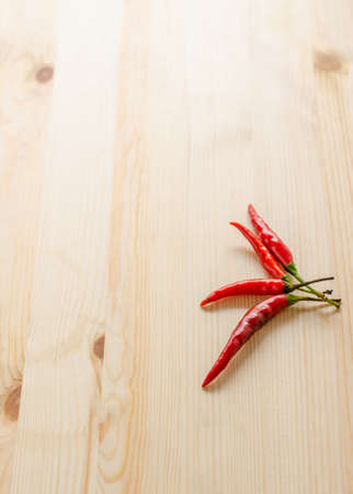 red and green chili four pieces of chili on wooden backgroundの写真素材