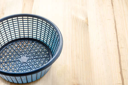 Blue plastic basket on the wooden backgroundの写真素材