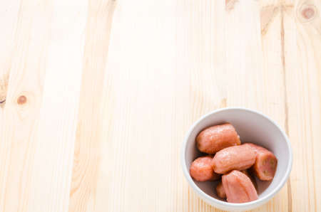 Banana with syrup in white bowl on right hand of wooden background, Thai dessert.の写真素材