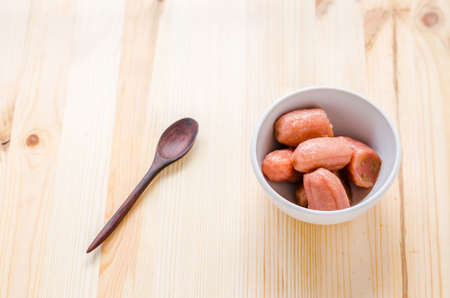 Banana with syrup in white bowl on wooden background, Thai dessert.の写真素材