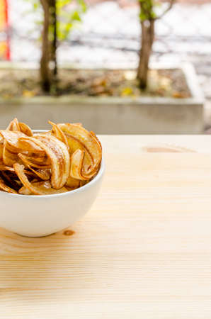 Sweet banana chips on wooden table backgroundの写真素材