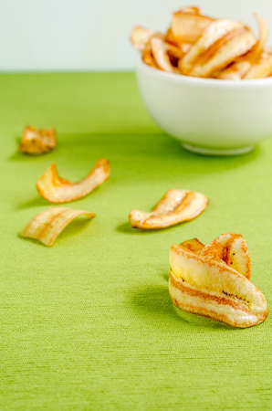 Sweet banana chips on green tablecloth backgroundの写真素材