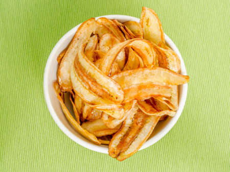 Sweet banana chips on green tablecloth backgroundの写真素材