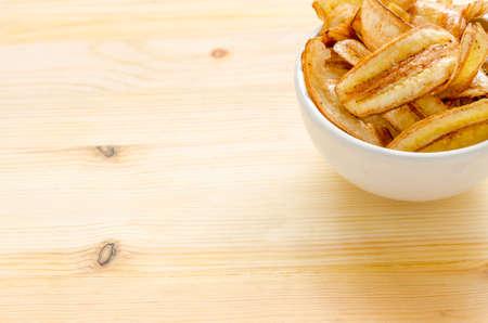 Sweet banana chips on wooden table backgroundの写真素材