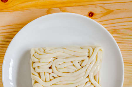 White udon noodle in white dish on wooden background