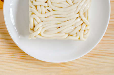 White udon noodle in white dish on wooden backgroundの写真素材