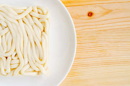 White udon noodle in white dish on wooden backgroundの写真素材