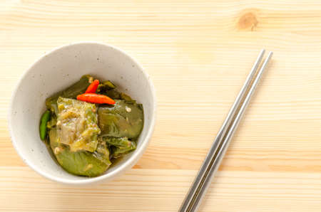 Fried eggplant with chili on wooden table background